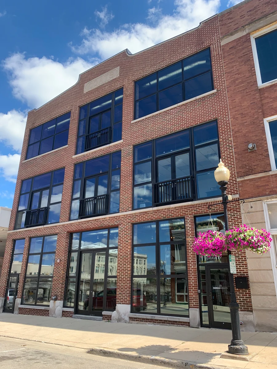 The brick Bureau Gravity building with tall windows and a street-level entrance.